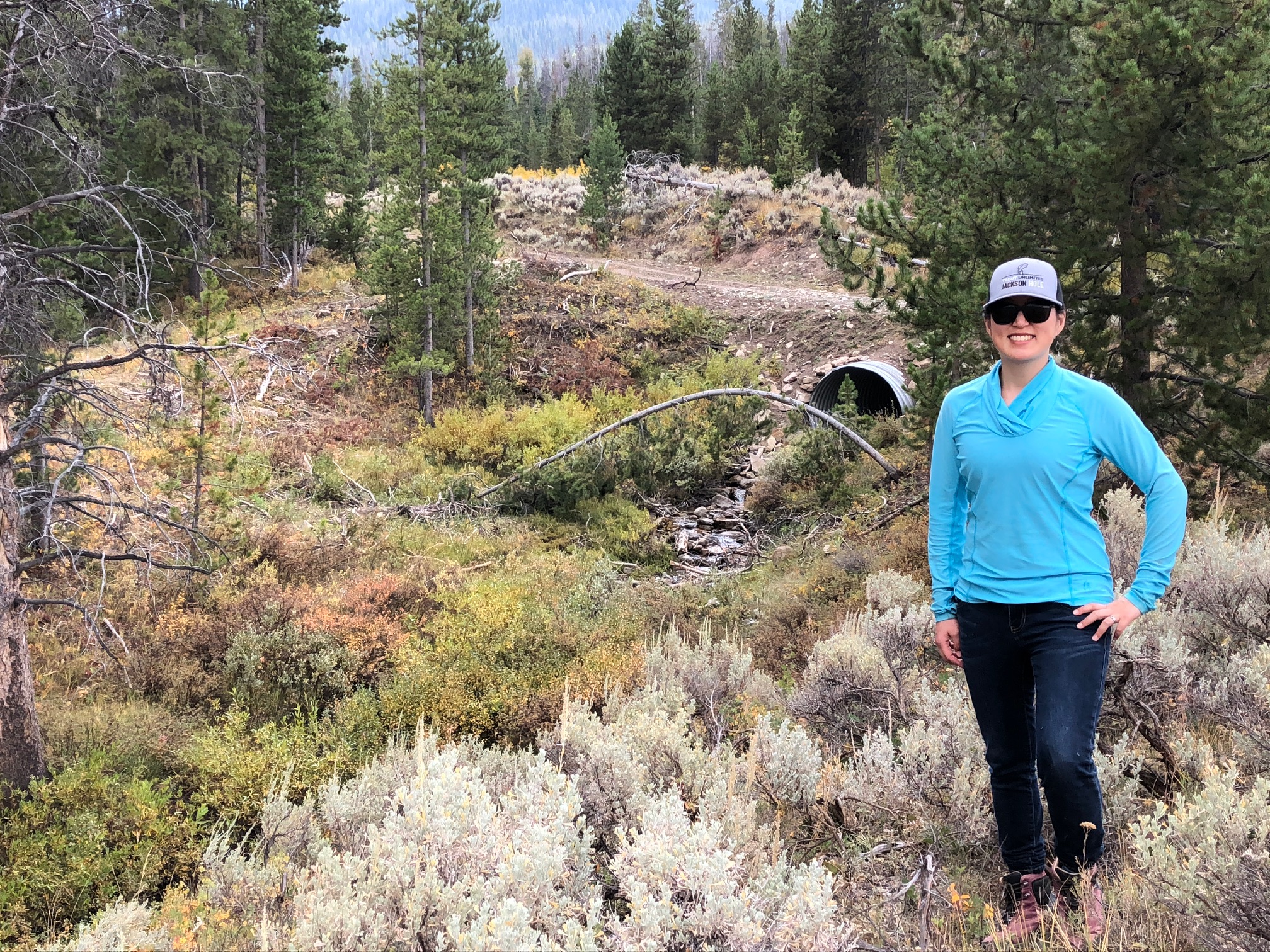Leslie Steen, TU Snake River Headwaters project manager in front of a new culvert installed on Lloyd Creek.