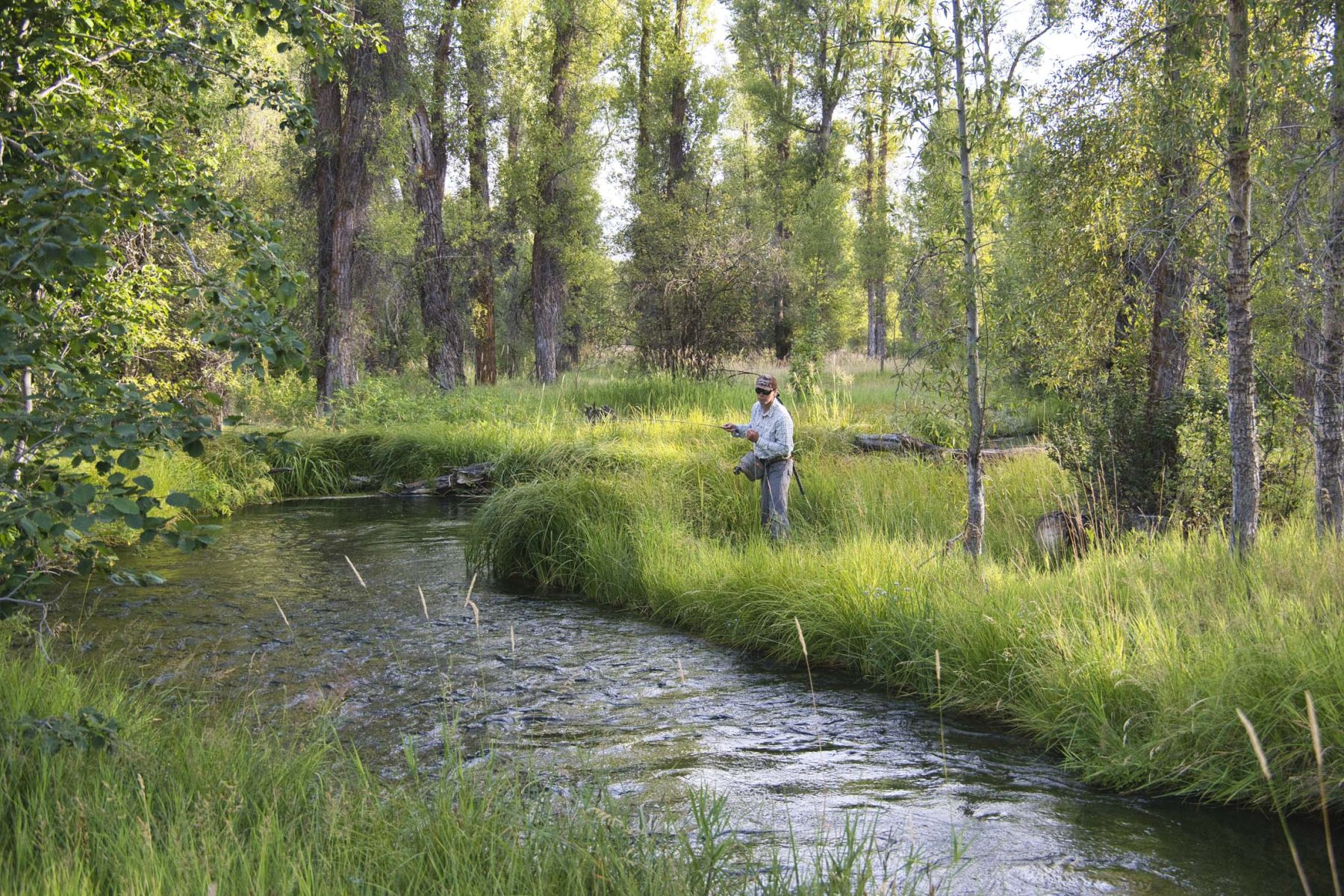 man fishing next to river