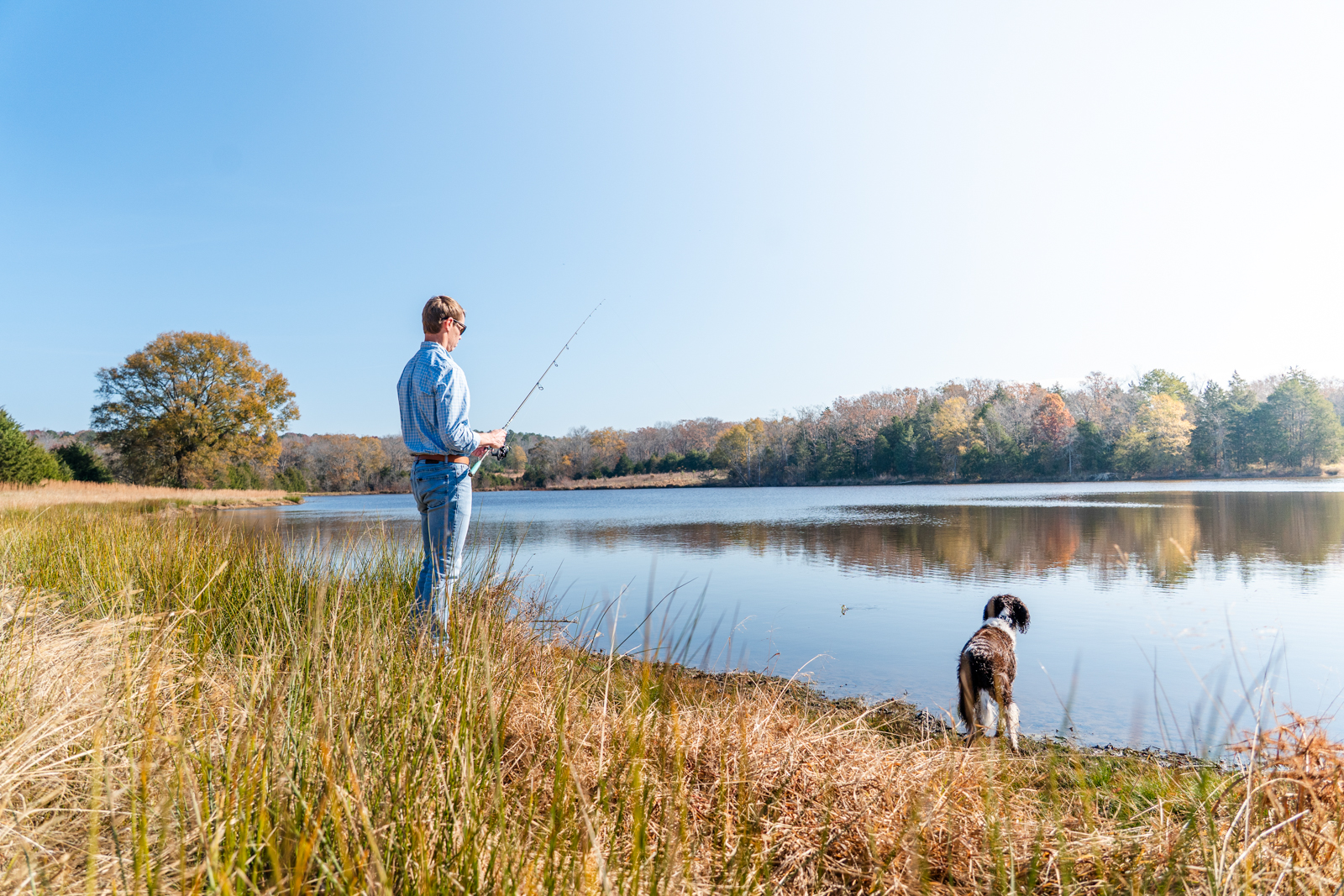 man fishing next to pond