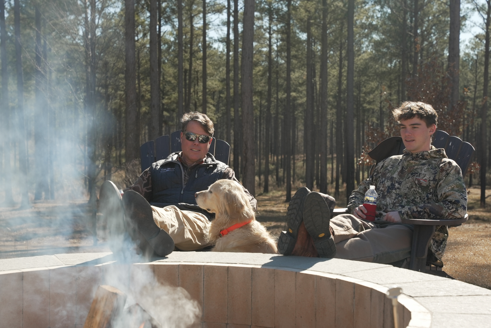 family and dog around the fire